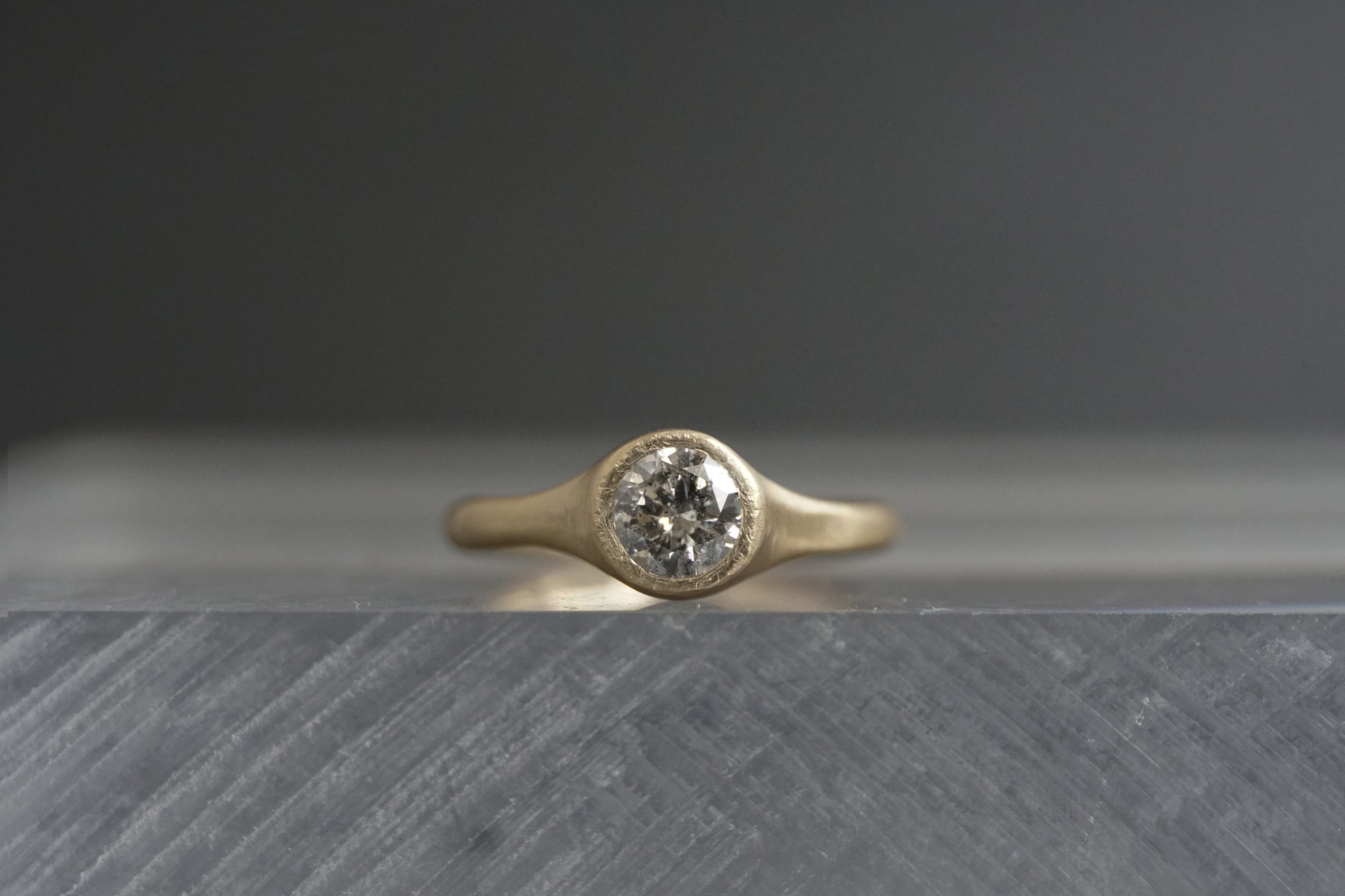 Handcrafted 14K yellow gold ring with a 0.5 ct salt and pepper diamond, showing the stone’s unique galaxy-like inclusions and matte wabi-sabi finish.