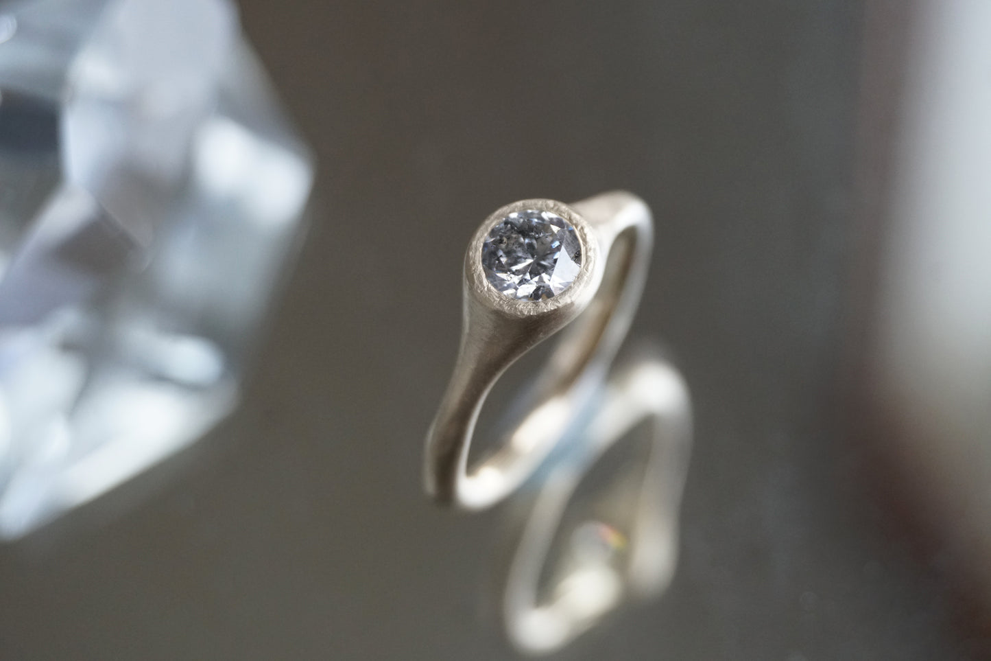Handcrafted 14K yellow gold ring with a 0.5 ct salt and pepper diamond, showing the stone’s unique galaxy-like inclusions and matte wabi-sabi finish.