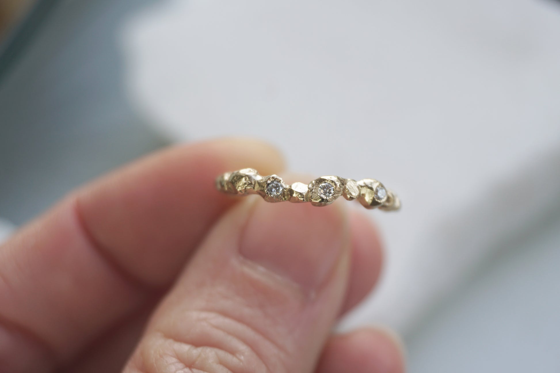 Handmade Fragment Diamond Ring in 14K gold featuring three VS diamonds across a softly textured matte band, shown in a close-up view. A minimalist, wabi-sabi inspired wedding or stacking ring crafted in the UK by Shanho Jewelry.