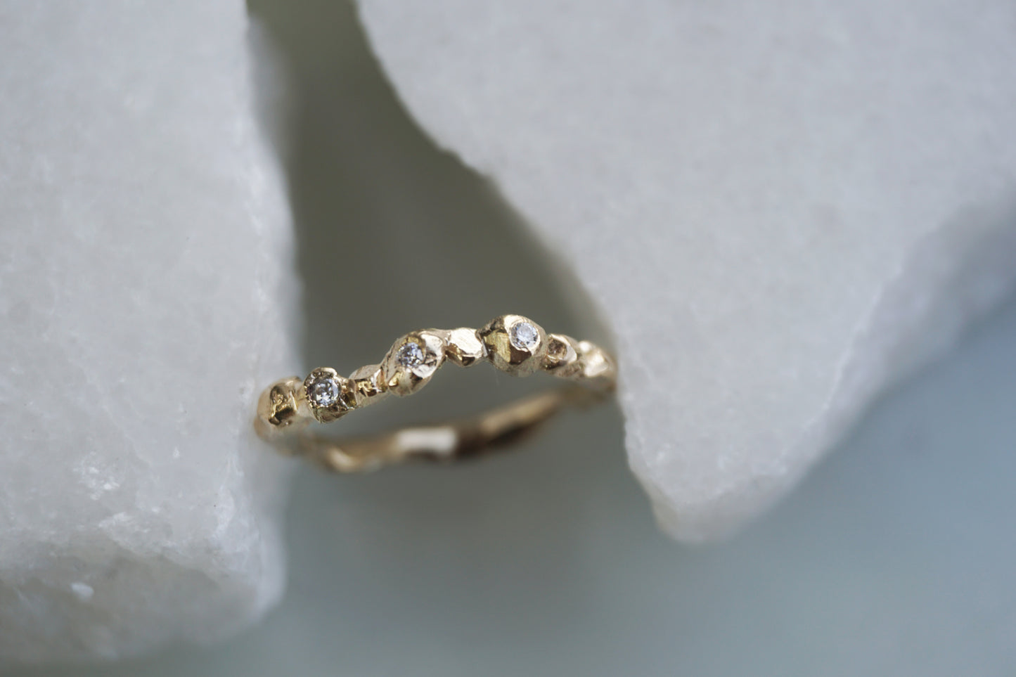 Handmade Fragment Diamond Ring in 14K gold featuring three VS diamonds across a softly textured matte band, shown in a close-up view. A minimalist, wabi-sabi inspired wedding or stacking ring crafted in the UK by Shanho Jewelry.