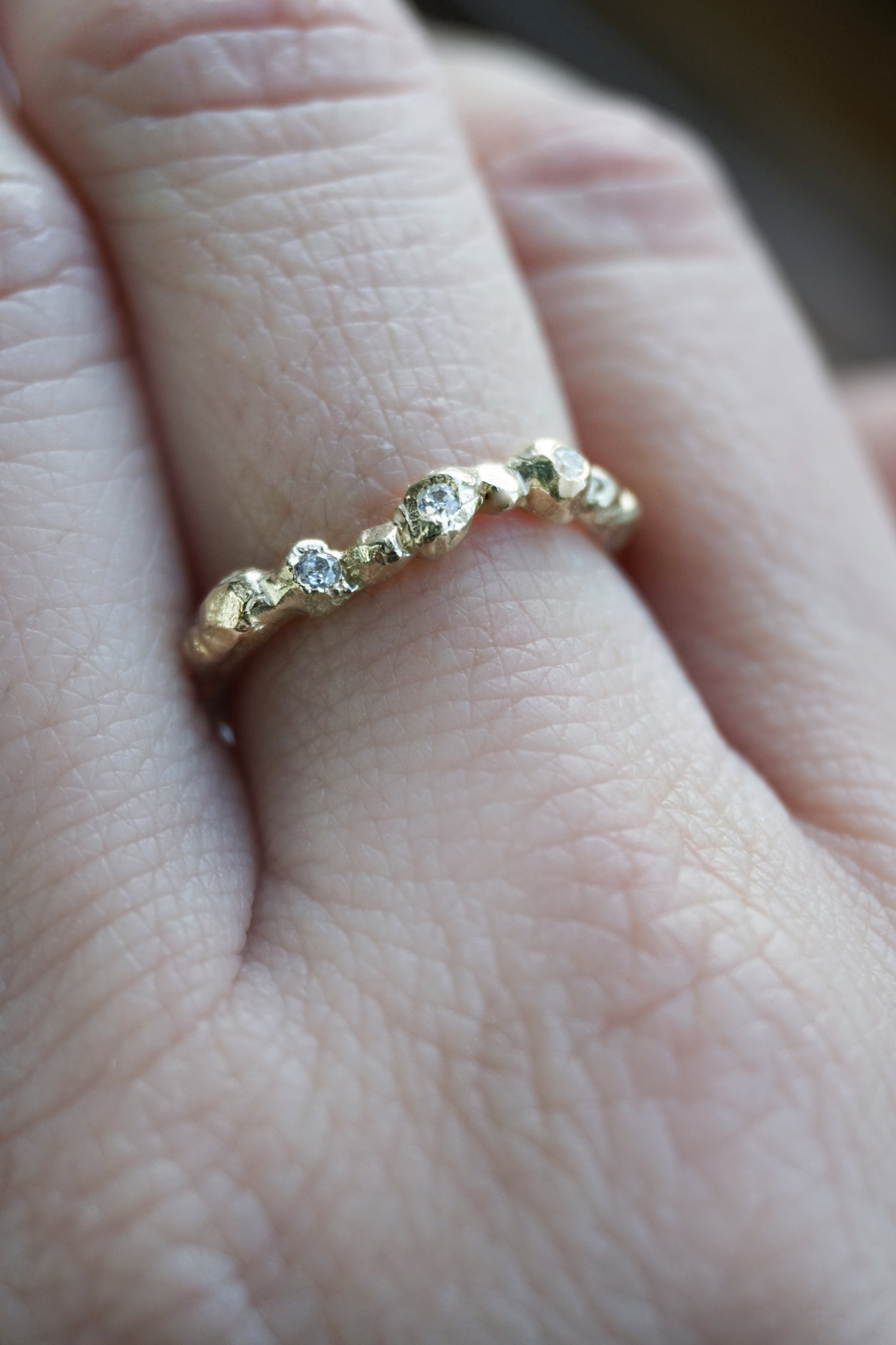 Handmade Fragment Diamond Ring in 14K gold featuring three VS diamonds across a softly textured matte band, shown in a close-up view. A minimalist, wabi-sabi inspired wedding or stacking ring crafted in the UK by Shanho Jewelry.