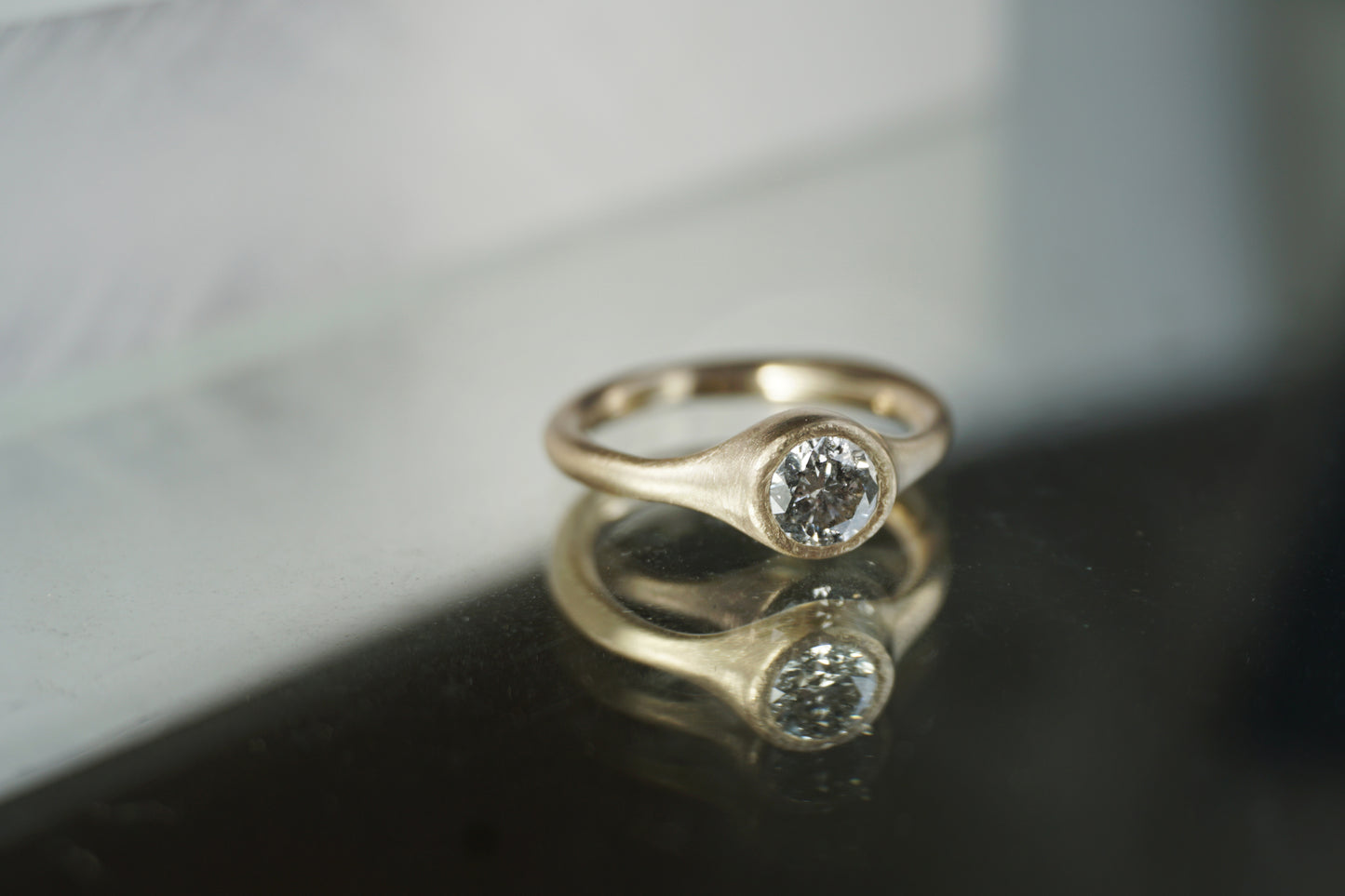 Minimalist salt and pepper diamond ring worn on hand, handmade in yellow gold with matte texture, reflecting quiet and natural elegance.