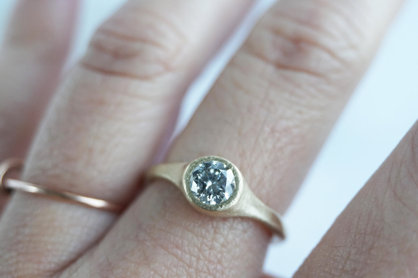 Minimalist salt and pepper diamond ring worn on hand, handmade in yellow gold with matte texture, reflecting quiet and natural elegance.