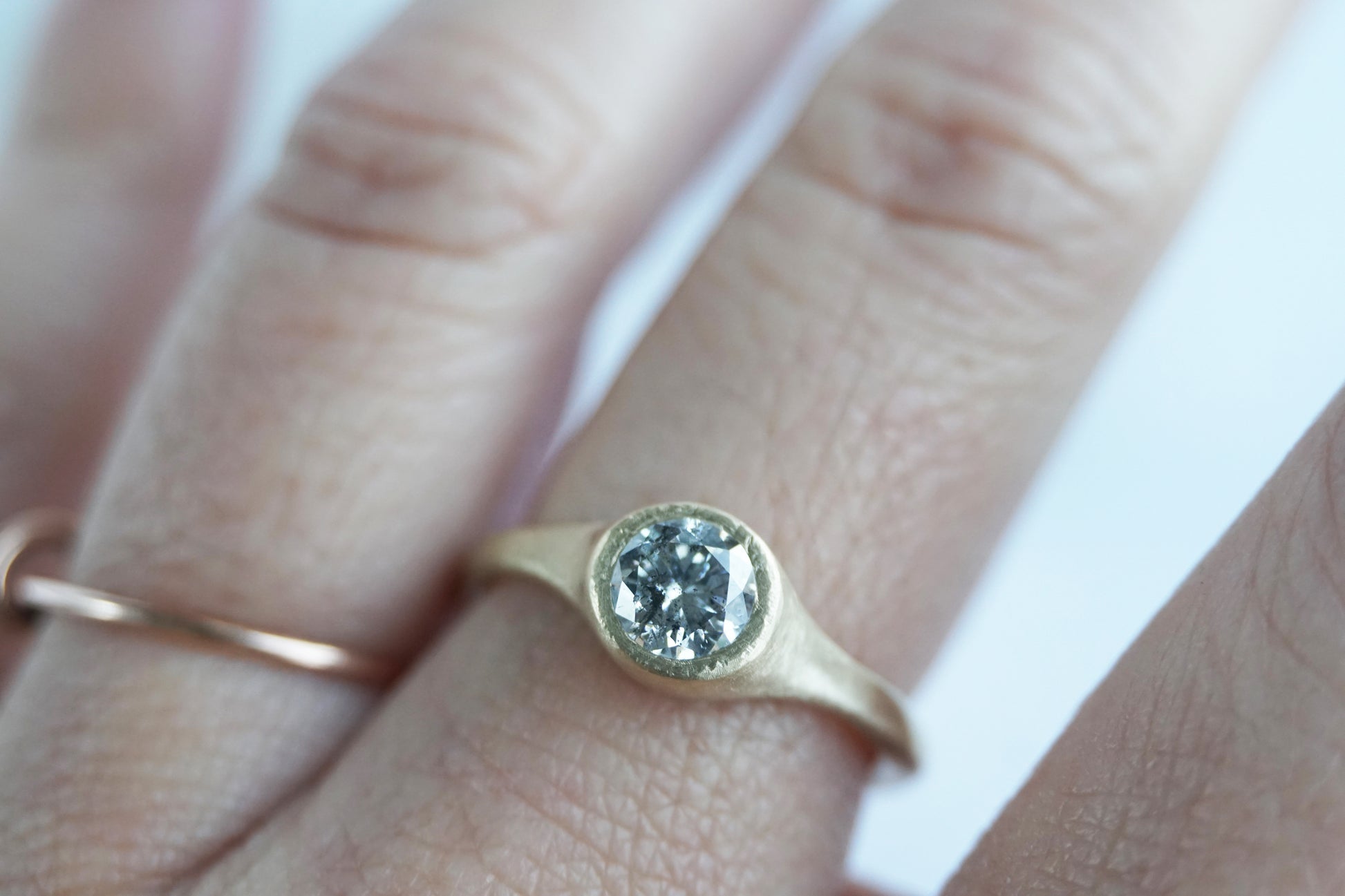Minimalist salt and pepper diamond ring worn on hand, handmade in yellow gold with matte texture, reflecting quiet and natural elegance.