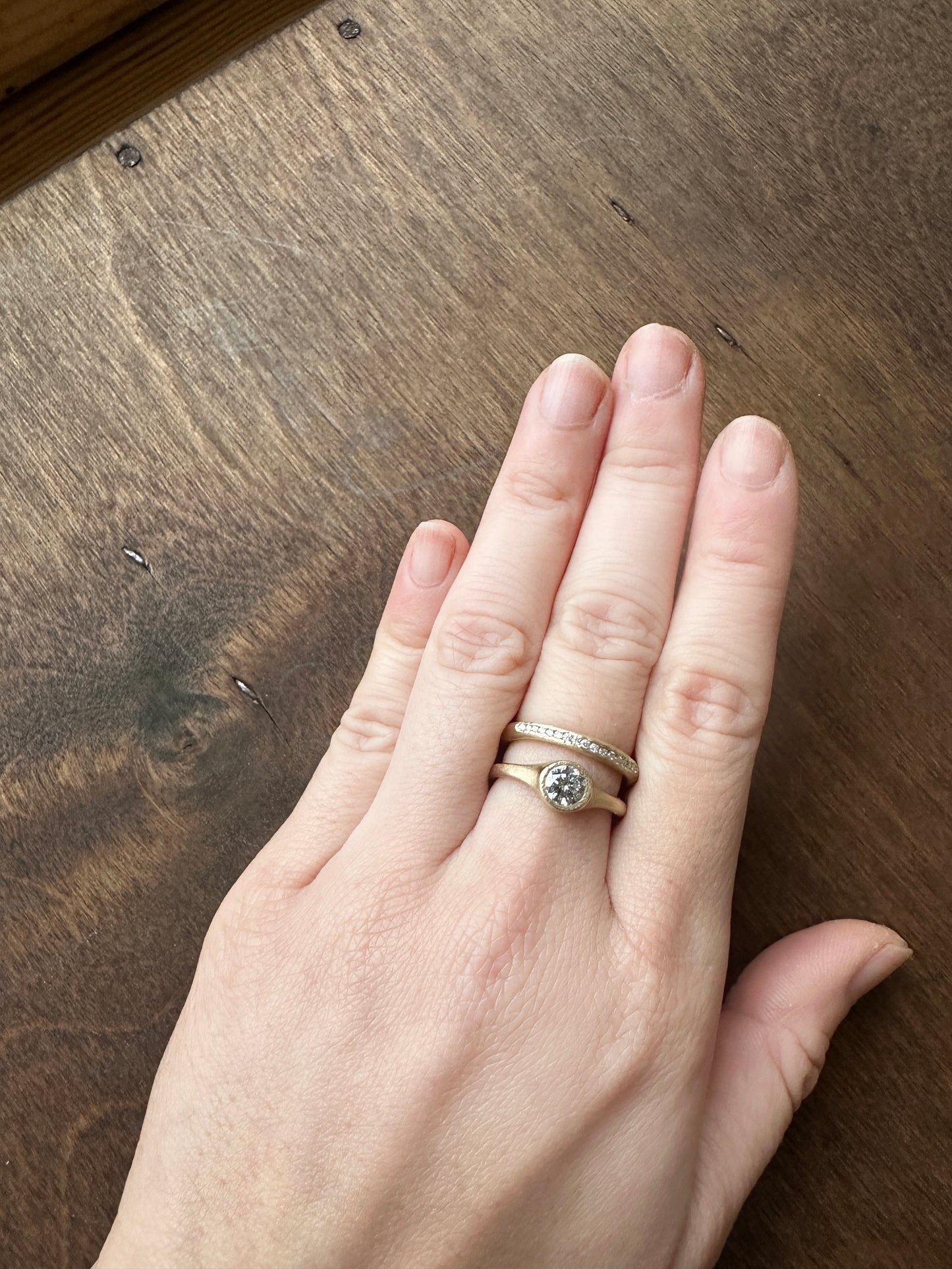 Minimalist salt and pepper diamond ring worn on hand, handmade in yellow gold with matte texture, reflecting quiet and natural elegance.