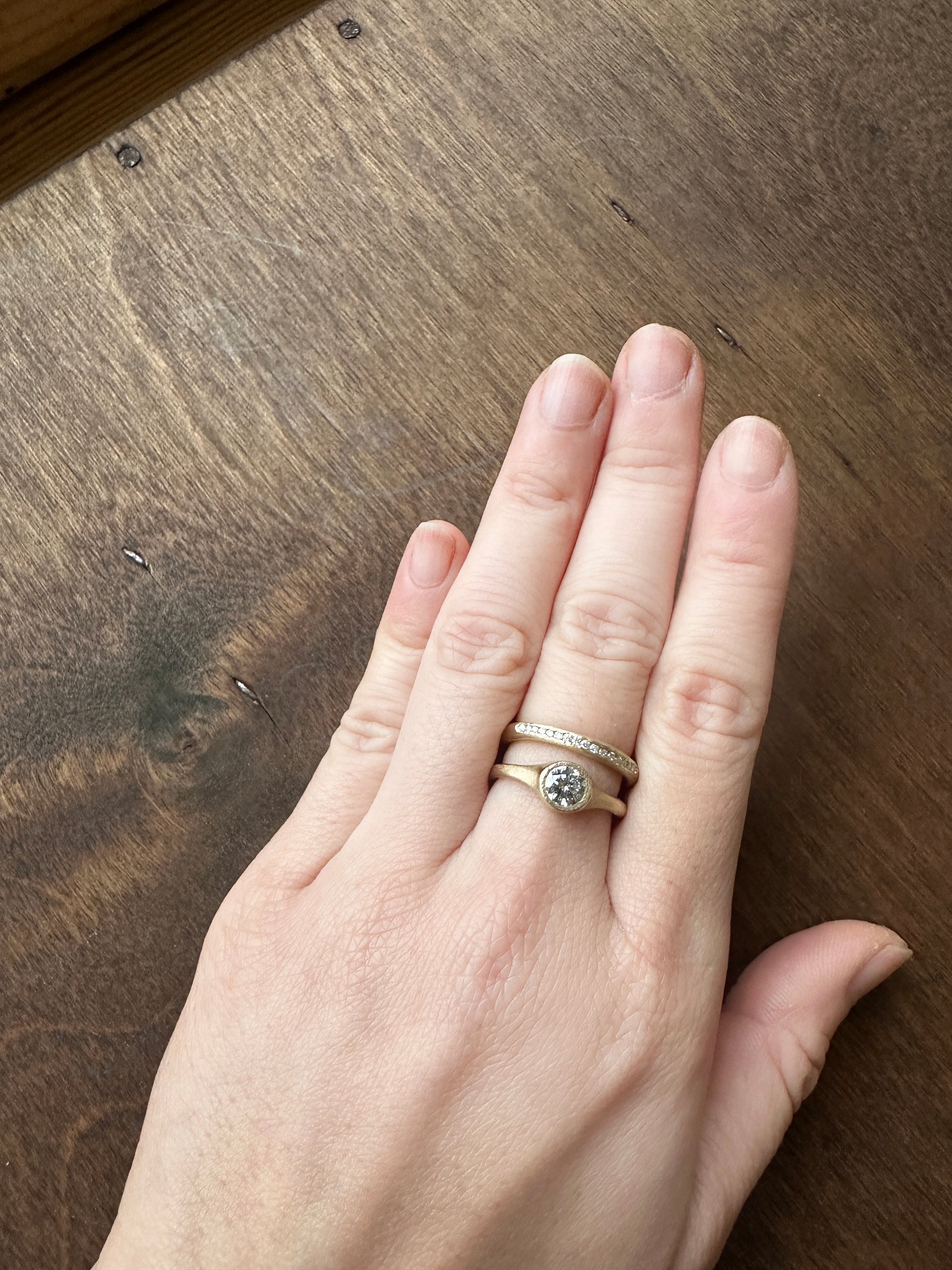 Minimalist salt and pepper diamond ring worn on hand, handmade in yellow gold with matte texture, reflecting quiet and natural elegance.