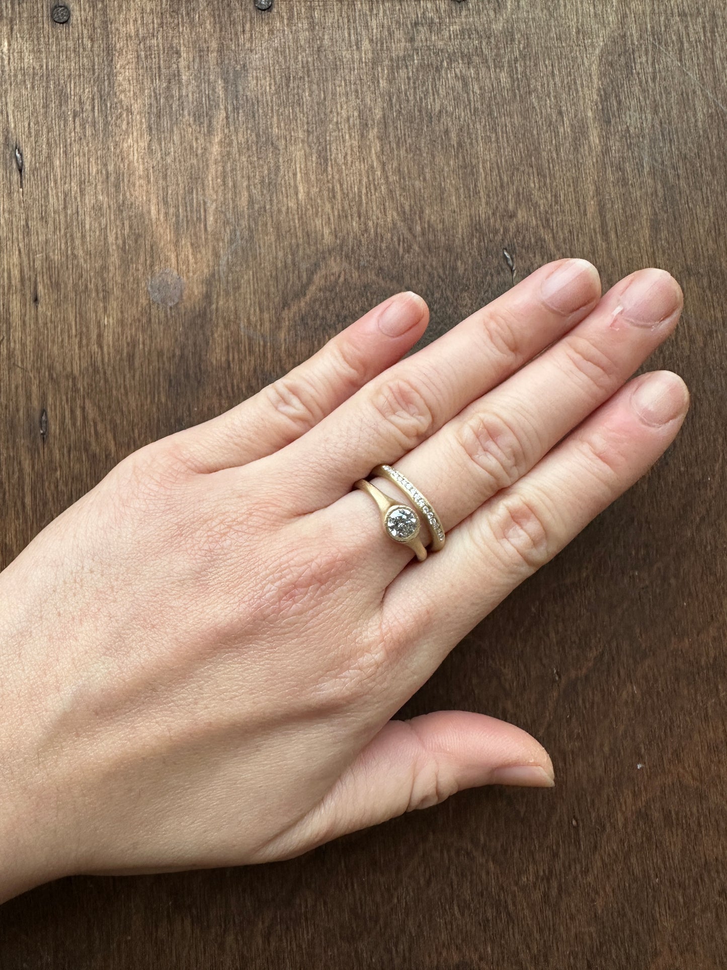 Minimalist salt and pepper diamond ring worn on hand, handmade in yellow gold with matte texture, reflecting quiet and natural elegance.