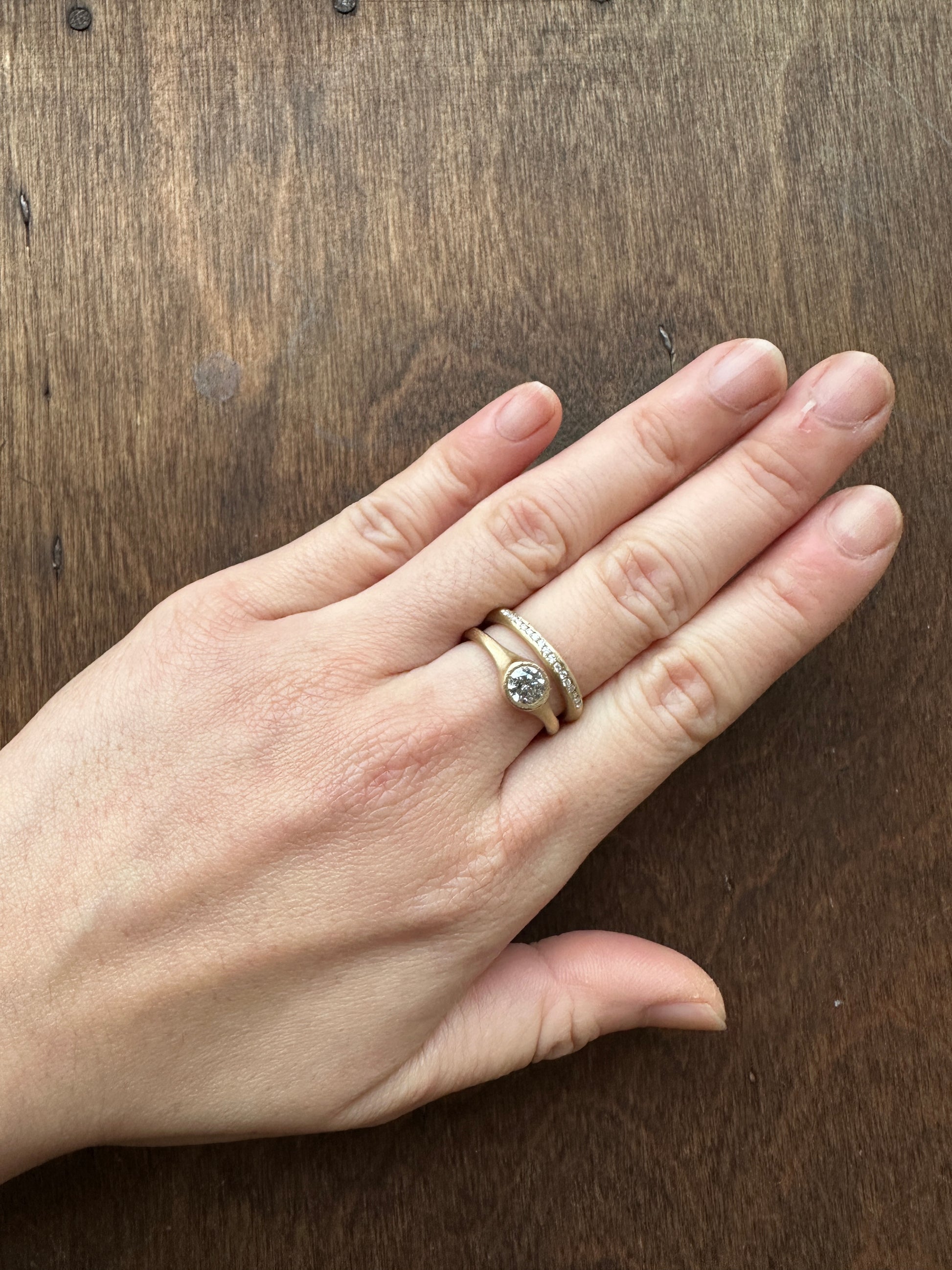 Minimalist salt and pepper diamond ring worn on hand, handmade in yellow gold with matte texture, reflecting quiet and natural elegance.